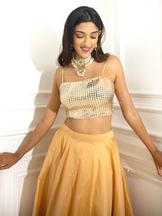 A two-piece Metallic Gold Shimmer lehenga set from the Shrena Hirawat collection. This beautiful metallic gold sequin embroidered bustier is paired with a gold taffeta skirt lehenga. The sequins embroidery with butter crepe lining enhance this lehenga set. Glamorous Sleeveless Lehenga For Festive Occasions, Festive Sleeveless Glamorous Lehenga, Gold Embellished Party Wear Sharara, Gold Sequined Sharara For Party Wear, Gold Sequined Sharara For Festivals, Gold Sequined Sets For Festive Occasions, Gold Lehenga With Mirror Work For Party, Gold Sequined Lehenga For Diwali, Festive Gold Sequined Choli