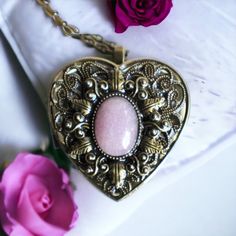 "Rose quartz music box pendant. This heart shaped music box pendant is inspired by the gorgeous music box pendants of era's gone by. Music box is pill box size, please look at the dimensions for exact size.  A perfect bronze heart locket has been adorned with a layer of filigree and an oval rose quartz stone. The stone is set in a bronze bezel. The filigree and bronze bezel have been finished with resin to preserve the beauty of this pendant. The music box winds from a key on the back of the pendant. The pendant hangs from a 30\" bronze chain with a dragonfly toggle clasp. The locket opens and closes by pushing the little button on the side and reveals a tiny working music box that plays an 18 note musical tune.  Choose the music box tune you would like at checkout.To listen to the music b Vintage Rose Gold Locket Necklace Gift, Vintage Rose Gold Locket Necklace For Gift, Vintage Brass Locket Necklace For Valentine's Day, Vintage Bronze Heart Pendant Necklace, Vintage Bronze Heart Necklace, Victorian Locket Necklace With Vintage Charm For Valentine's Day, Victorian Locket Necklace For Valentine's Day, Bronze Heart-shaped Jewelry For Gifts, Vintage Rose Gold Locket Necklace For Valentine's Day