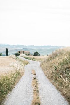 an empty road in the middle of a field