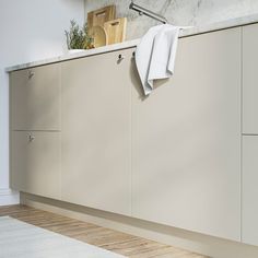 a white towel hanging on the side of a kitchen cabinet next to a counter top