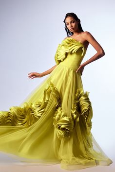 Lime green tulle and organza one-shoulder draped A-line dress. Featuring an off-the-shoulder design, and a draped bodice. Complemented with a tulle A-line skirt with organza ruffles around it.