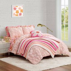 a bedroom with white brick walls and pink bedding