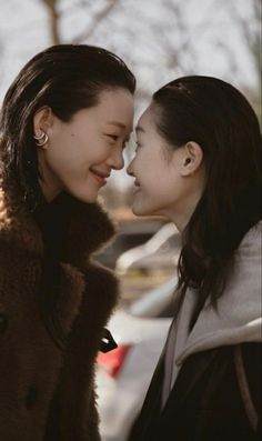 two women standing next to each other in the snow