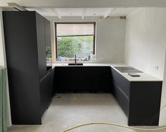 an empty kitchen with black cabinets and white counter tops is being remodeled in preparation for painting