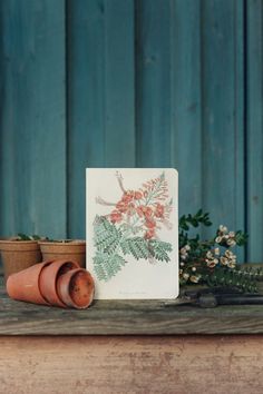 a card sitting on top of a wooden table next to potted plants and a planter