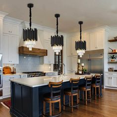 a large kitchen with an island in the middle and lots of stools around it