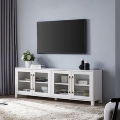 a flat screen tv mounted to the side of a white entertainment center in a living room