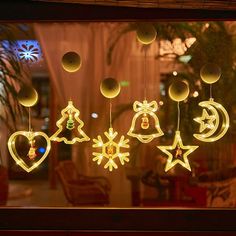 a window with christmas decorations hanging from it's sides and lights in the windows