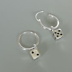 A PAIR of sterling silver hoops. Comes with a detachable dice charm. The charm is multipurpose and can be used with a neck or bracelet chain too. Dimension: Hoop- 12x1 mm Charm: 5 x8 mm Drop length- 19 mm These earrings are made of real 925 hypoallergenic sterling silver. Please let me know if you want the piece in a gift box. I can write out a message from you to the receiver if needed. Please be free to contact me at... bhavnakwintra1956@gmail.com More hoops: https://www.etsy.com/your/shops/Th Silver Dangling Charms Earrings As Gift, Nickel-free Silver Dangle Huggie Earrings, Silver Earrings With Dangling Charms For Gifting, Silver Nickel-free Dangle Huggie Earrings, Silver Earrings With Dangling Charms As Gift, Silver Dangle Huggie Earrings Nickel-free, Silver Huggie Earrings With Charms, Charm Small Hoop Metal Earrings, Silver Charm Hoop Earrings