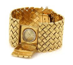 This is a stunning Retro Era wide watch bracelet, it is crafted from solid 18k yellow gold with a polished textured finish. It is wide and has a rectangular shape open and close cover for a small round Universal Geneve hand winding watch. There are small groove design box shape links fitted together in a symmetrical to form a 1.25 inches wide band, it fastens with a push in clasp with chain attach and latch for added security. Material: 18k yellow gold     Hallmark: Made Italy 18k Measurement: Universal Geneve, Design Box, Retro Era, Fancy Design, Design Bracelet, Gold Feathers, Heart And Key, Circle Diamond, Watch Bracelet