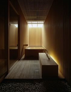 a wooden room with two benches and lights on the wall, along with gravel flooring