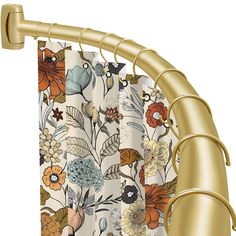 a shower curtain with flowers on it and gold metal rod ends, hanging from the side