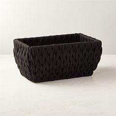 a black basket sitting on top of a white table