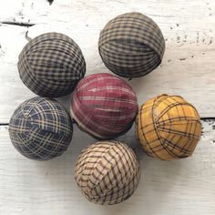 four different colored balls sitting on top of a white wooden table next to each other