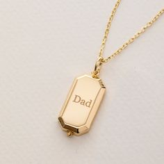 a gold necklace with the word dad engraved on it's front and back sides