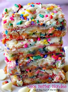 a stack of colorful sprinkles on top of each other next to a plate