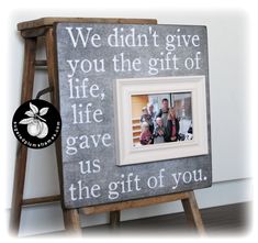 a wooden ladder with a picture frame on it that says we didn't give you the gift of life, gave us the gift of you