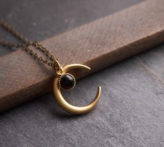 "A bewitching necklace: the delicate onyx drop is a perfect match for the matte finished, 24k gold plated brass moon. This piece looks gorgeous worn on its own or is fantastic layered with other necklaces. ⟴ Onyx is the ancient birthstone for July and is associated with the zodiac sign of Leo Turquoise: https://www.etsy.com/ca/listing/735203333/moon-necklace-celestial-jewelry Amethyst: https://www.etsy.com/ca/listing/741246762/amethyst-necklace-boho-necklace Moonstone: https://www.etsy.com/ca/li Witch Moon, Half Moon Necklace, Witch Necklace, Gold Moon Necklace, Crescent Necklace, Witch Jewelry, Celestial Necklace, Onyx Necklace, Elegant Pendant