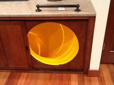 a yellow bowl sitting on top of a wooden cabinet