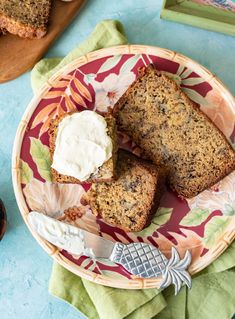 slices of banana bread on a floral plate with butter and spoons next to it