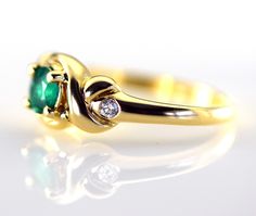 A lovely Columbian Emerald accented with two sparkling diamonds in a 14k yellow gold ring. The emerald is a 5 mm round and weighs .50 carats and is a genuine emerald from Columbia. The two diamonds are round brilliants with a total weight of .08 carats G-H color VS2 clarity The metal is 14k yellow gold and the ring is 8.4m wide at the stone Ring weight 4.45 grams Size 7 3/4 Jewelry from Stowe Gems arrives beautifully packaged in a gift box. If you have any questions about this piece or if we can Elegant Three Stone Birthstone Ring In 14k Gold, Classic Brilliant Cut May Birthstone Ring, Timeless Emerald Anniversary Ring, Timeless Emerald Wedding Anniversary Ring, Elegant Three Stone Birthstone Ring For Formal Occasions, Elegant Three Stone Birthstone Ring For Anniversary, Elegant Three-stone Birthstone Ring For Anniversary, Elegant Three Stone Diamond Birthstone Ring, Elegant Three-stone Diamond Birthstone Ring