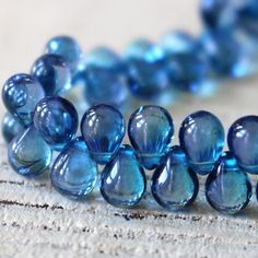 blue glass beads are arranged on a piece of wood