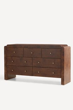 a large wooden dresser with six drawers and gold knobs on the top, against a white background