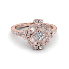 a rose gold ring with diamonds in the center and an intricate design on the band