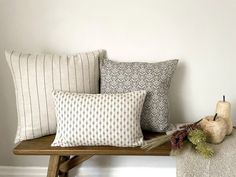 four pillows are sitting on a wooden bench