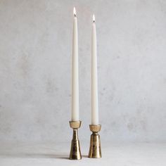 two white candles sitting next to each other