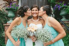 three bridesmaids kissing each other while holding bouquets