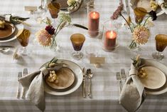 the table is set with plates, silverware and candles