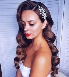 a woman with long hair wearing a white dress and a headpiece in her hair