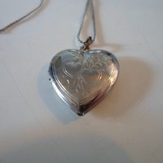 Bright Silver tone picture locket is  .75"w x.85"h with and 10" chain. Good Vintage condition note photos Heart is nicely engraved with 2 interlocking hearts with vines surrounding them. A nice size for anyone. Opens nicely for photos. Free shipping to USA Vintage Double Heart Engraved Necklace, Vintage Engraved Double Heart Necklace, Vintage Personalized Heart Necklace Keepsake, Personalized Vintage Heart Necklace Keepsake, Vintage Double Heart Engraved Locket Necklace, Vintage Heart Necklace For Valentine's Day Keepsake, Vintage Personalized Heart Necklace For Anniversary, Personalized Vintage Heart Necklace For Anniversary, Silver Etched Necklace For Valentine's Day