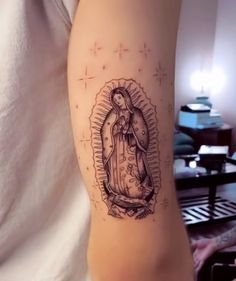 a woman's arm with a tattoo of the virgin mary in black and white