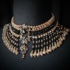 Luxury Temple Jewelry For Formal Occasions, Luxury Temple Jewelry Style Bridal Choker, Luxury Jeweled Elegant Temple Necklace, Luxury Antique Gold Jewelry For Collectors, Luxury Gold Plated Ceremonial Jewelry, Luxury Spiritual Jewelry For Navratri, Luxury Black Beaded Necklaces For Evening, Gold Beaded Necklaces With Black Beads For Evening, Gold Beaded Necklace With Black Beads For Evening