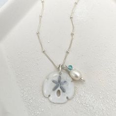 Legend has it that finding a sand dollar during a beach stroll is considered a lucky omen. So take a little bit of the beach and good luck with you wherever you go with our gorgeous Sand Dollar Charm Necklace. Features our most loved satellite chain, freshwater pearl, and blue zircon accents. Freshwater Baroque Pearl size: 6 to 8mm Blue Zircon roundel gemstone 4mm 14kt gold fill or sterling silver round beads 2mm 14kt gold fill or sterling silver satellite chain Real sand dollars are preserved a Sand Dollars, Charm Necklace Silver, Pearl Choker Necklace, Sand Dollar, Blue Zircon, Pearl Choker, Pearl Size, Baroque Pearls, 14kt Gold