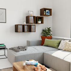 a living room filled with furniture and bookshelves next to a wall mounted book shelf