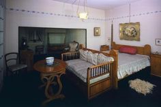 a bedroom with a bed, chair and table in it's center area is shown