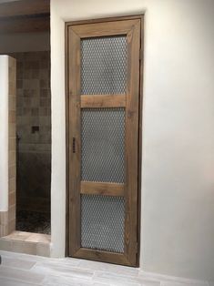 a bathroom with a wooden door and tiled floor