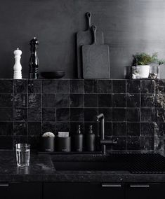 black and white photograph of kitchen sink with utensils on the counter top in front of it