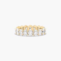 a yellow gold ring with five round cut diamonds on the side, set against a white background