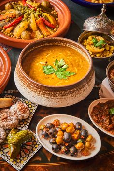 a table topped with lots of different types of food and dishes filled with sauces