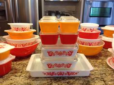 there are many different colored dishes on the counter