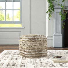 a white and brown ottoman sitting on top of a rug