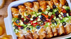 a casserole dish filled with chicken, olives, and lettuce