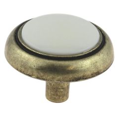 an antique brass cabinet door knob with white glass in the center and black trim on top