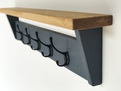 a wooden shelf with metal hooks on it