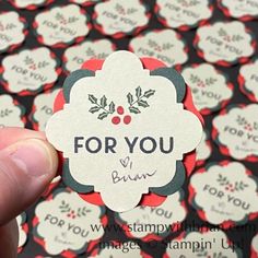 a hand holding up a sticker with the words for you on it in front of many