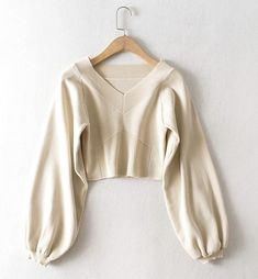 The Cream Balloon Sleeve Knit Sweater is a stylish addition to any wardrobe, offering a blend of comfort and contemporary fashion. This sweater features an elegant V-neckline and unique geometric ribbed detailing on the front, adding a touch of sophistication to its casual appeal. The soft cream color makes it versatile and easy to pair with a variety of outfits, whether youre dressing up for a day out or keeping it cozy at home.Crafted from high-quality knit fabric, this sweater ensures a comfo Chic Beige V-neck Winter Sweater, Elegant Long Sleeve V-neck Sweater For Winter, Elegant Knit V-neck Sweater For Winter, Spring V-neck Stretch Sweater, Elegant Beige V-neck Sweater For Winter, Elegant Stretch V-neck Sweater For Winter, Chic Beige V-neck Sweater For Winter, Beige V-neck Trendy Knit Top, Winter V-neck Textured Knit Cardigan